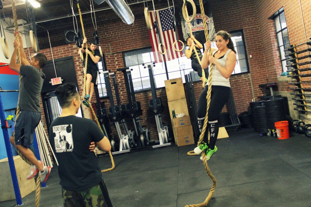 Coach Tom working with Sarah on the rope climb foot clamp: J-hook.